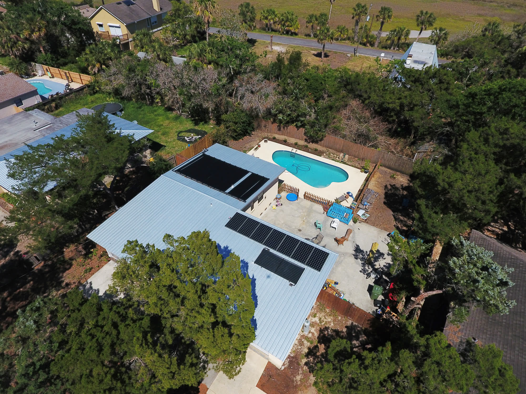 Solar-Fit pool heating collectors on a Florida home, pool in the yard below